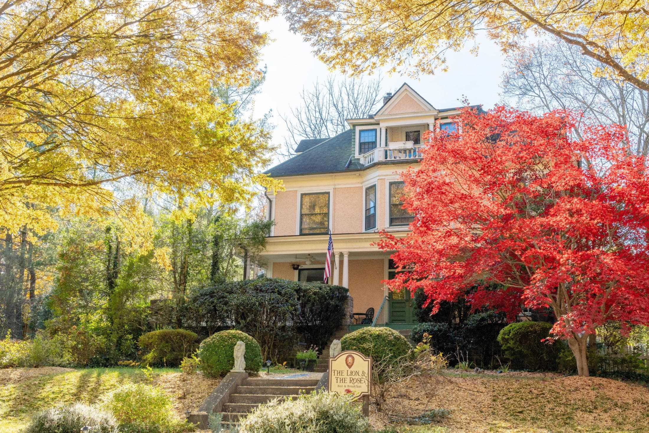 Beaufort House B&B in Asheville, a yellow house surrounded by red and yellow-leafed trees