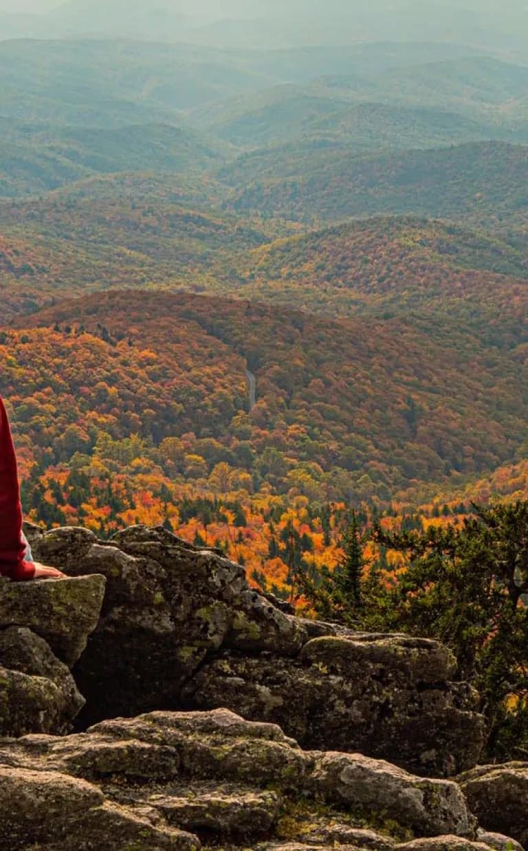 Woman on rock overlooking fall colors Asheville NC