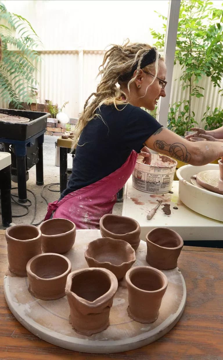 A group of people work with clay on potters wheels in Asheville